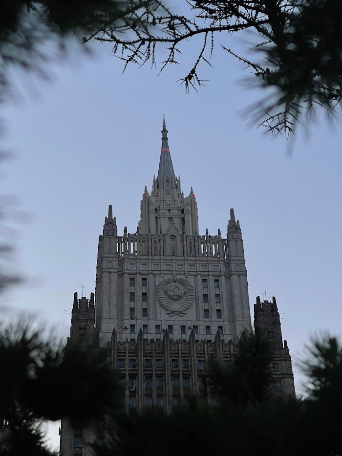 about-02 Low-angle view of a gothic-revival government building in Moscow through trees.